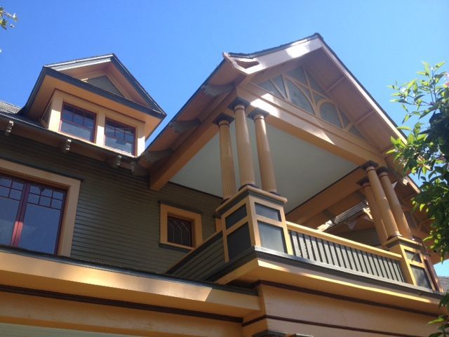 A house with a balcony and a blue sky in the background