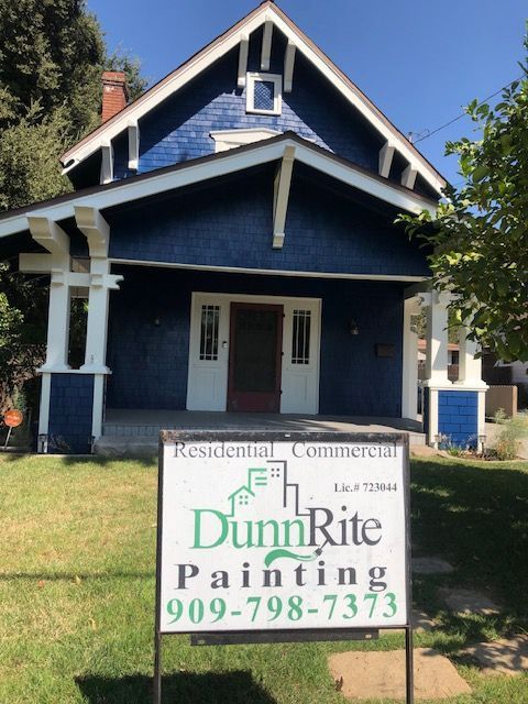 A dunn rite painting sign in front of a blue house