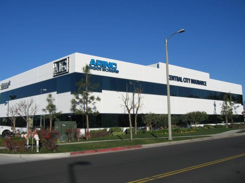 Two men are painting the side of a building.