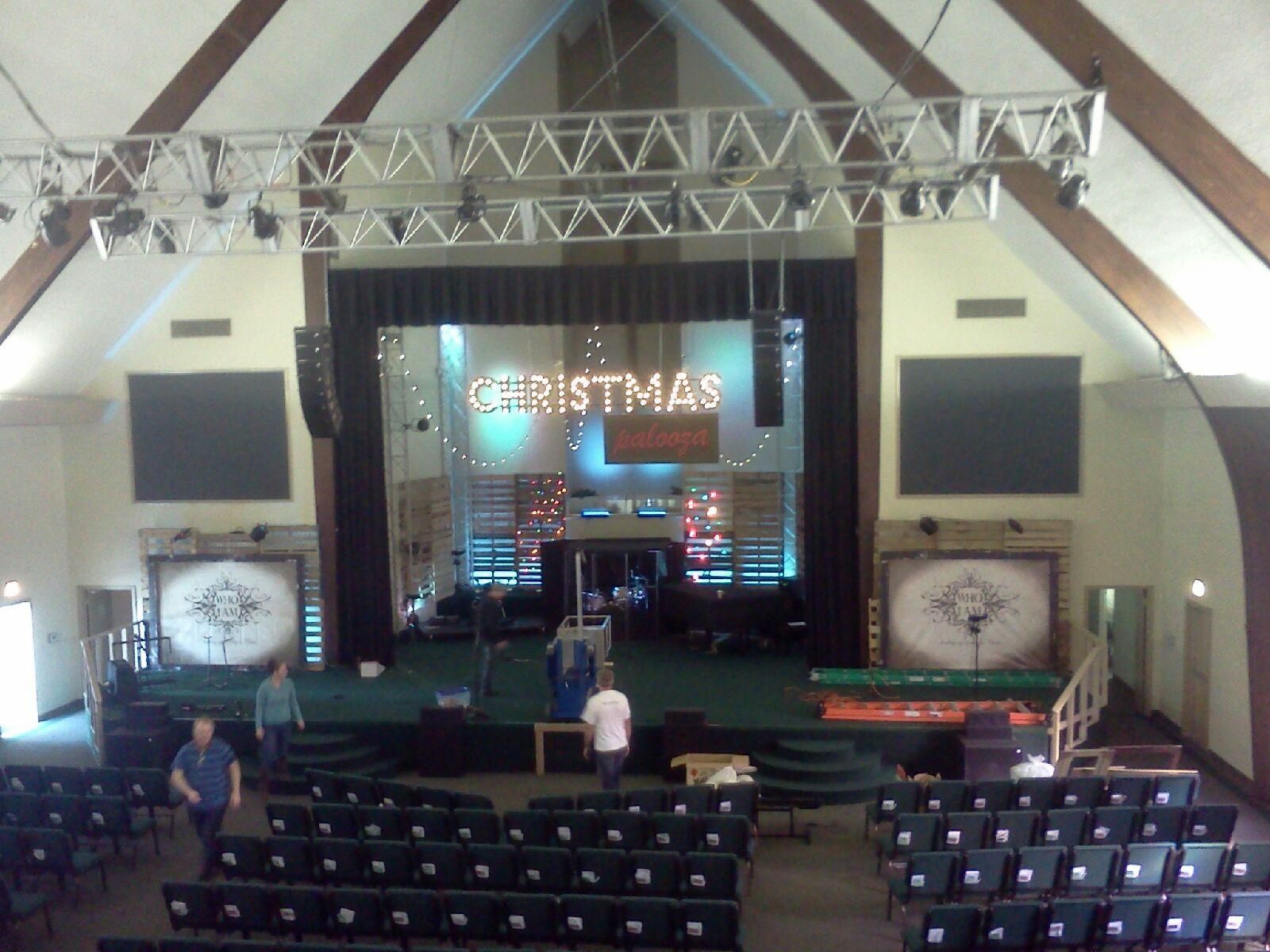 A large auditorium with a Christmas sign on the stage