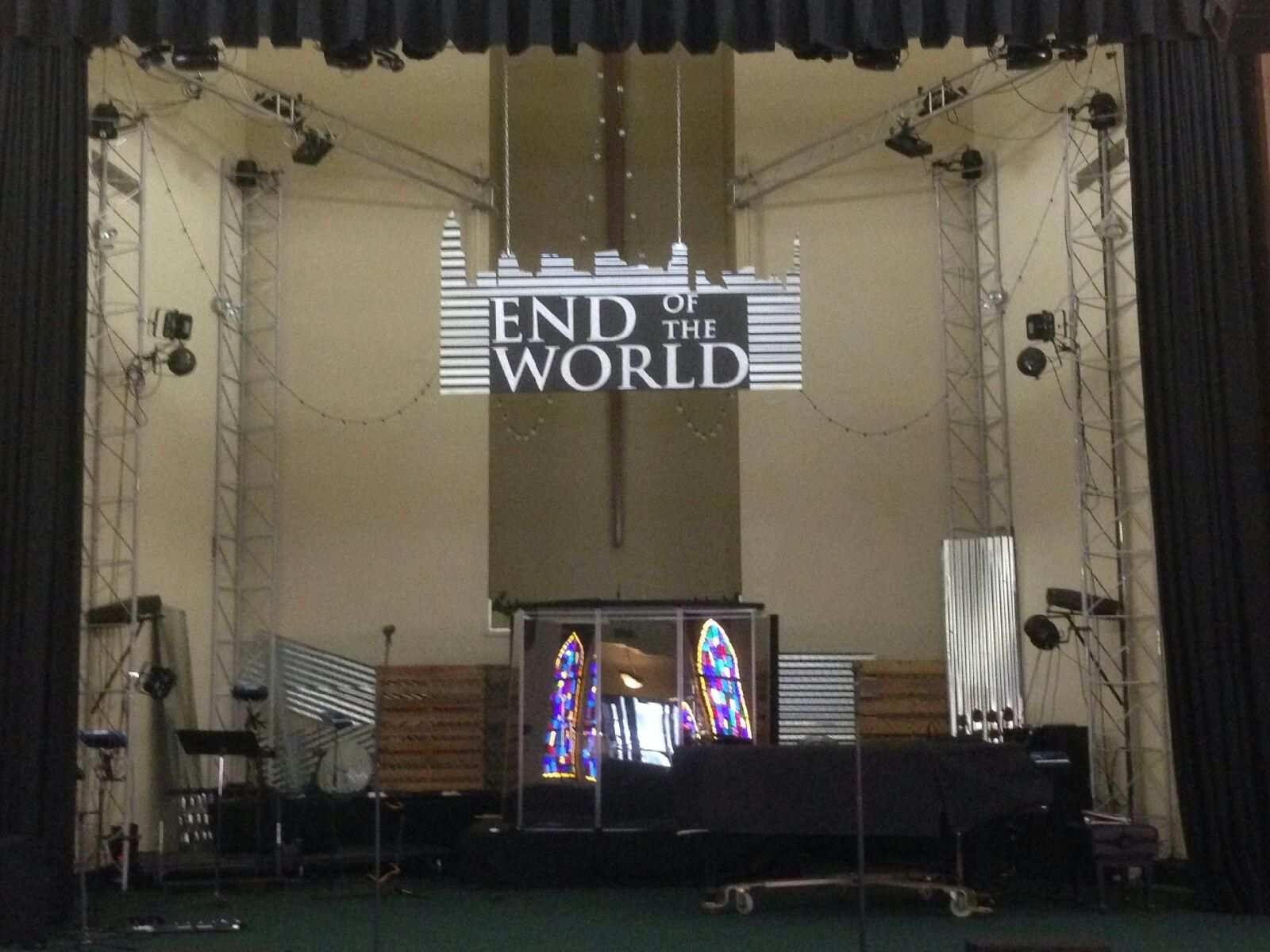 A stage with the words end of the world projected on it