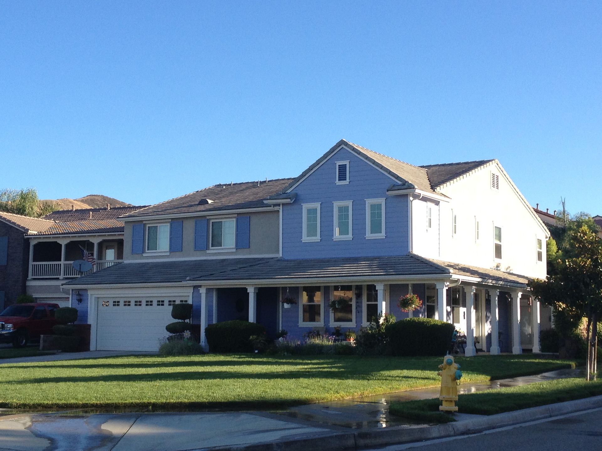 A large blue and white house with a fire hydrant in front of it