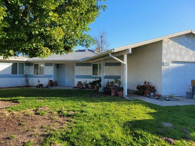 A white house with a large lawn in front of it.
