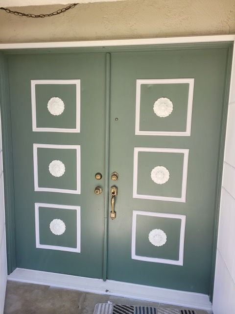 A green door with white squares and circles on it