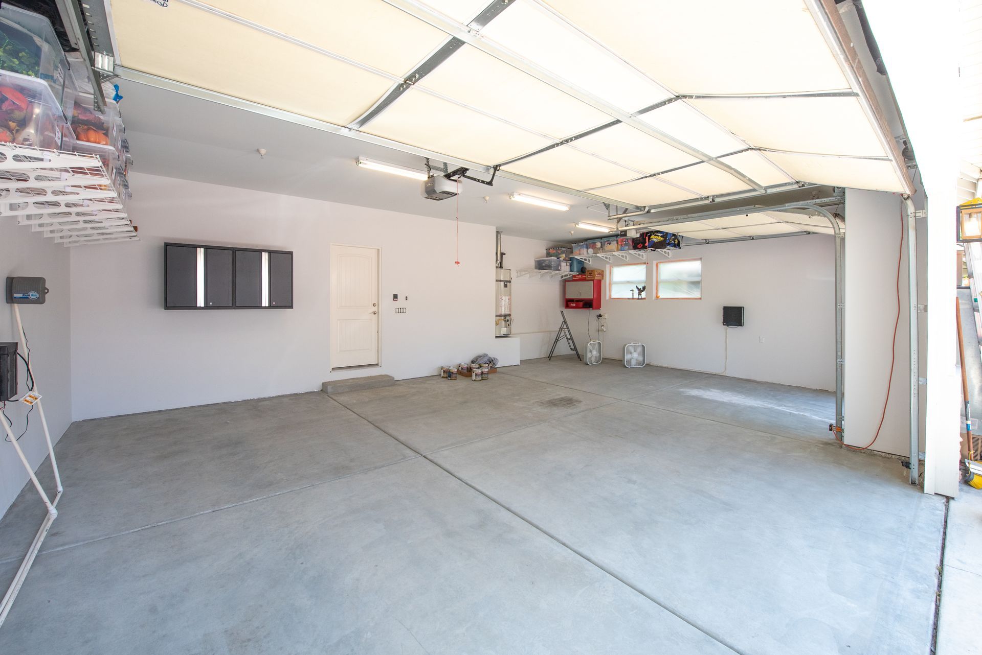 A large empty garage with a garage door open.