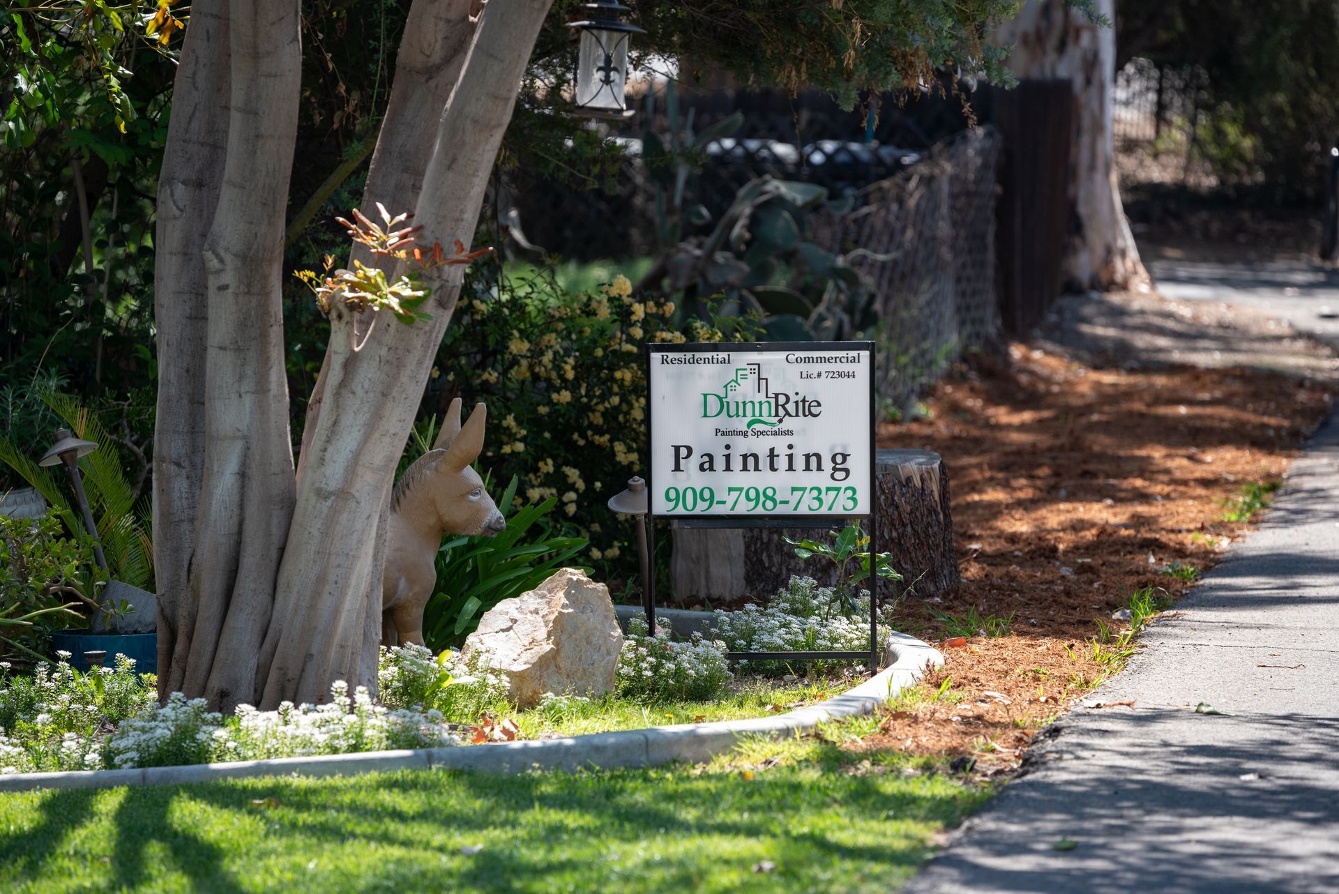 A sign for a painting company is on the side of a road.