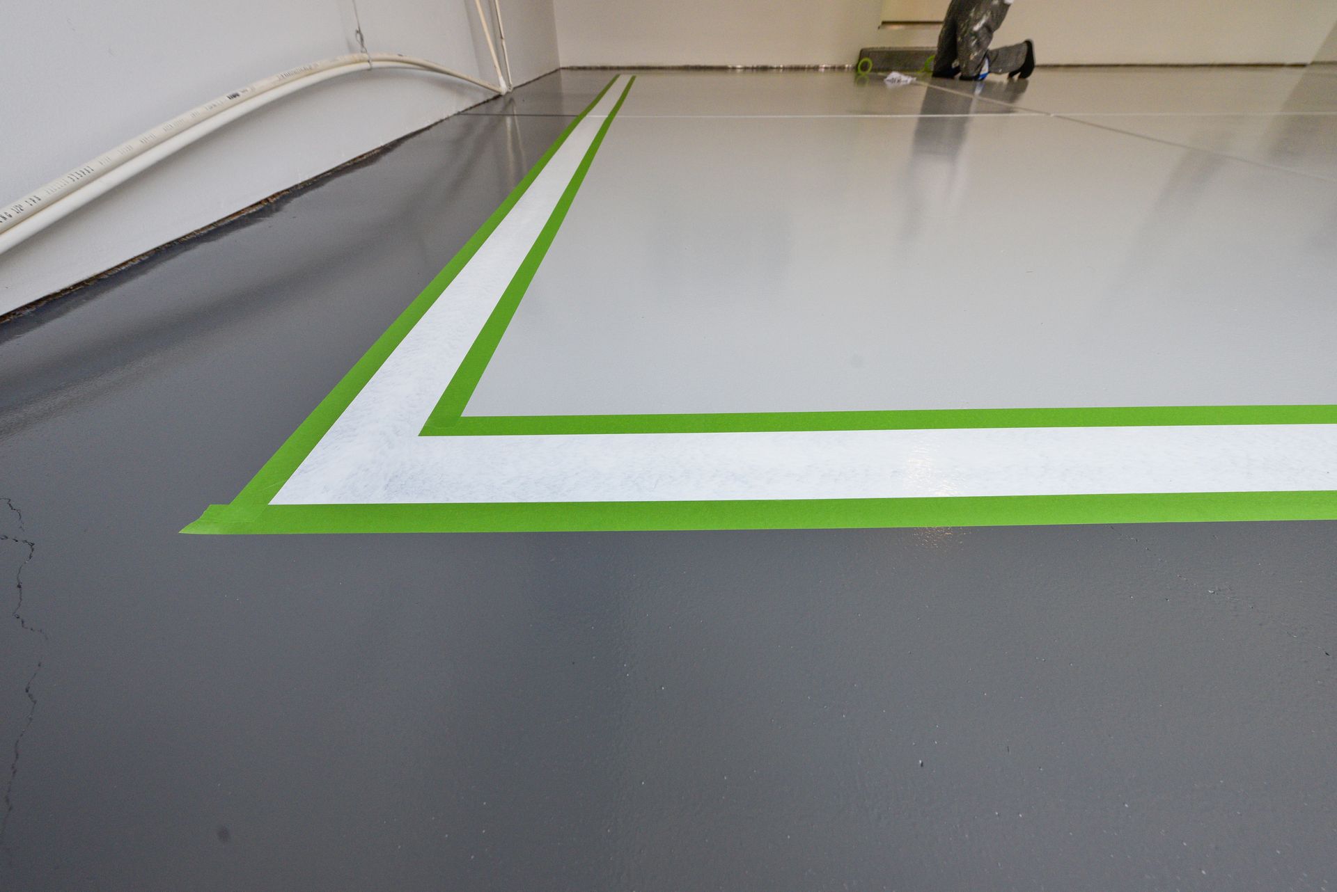 A gray and white epoxy floor with a green stripe on it.