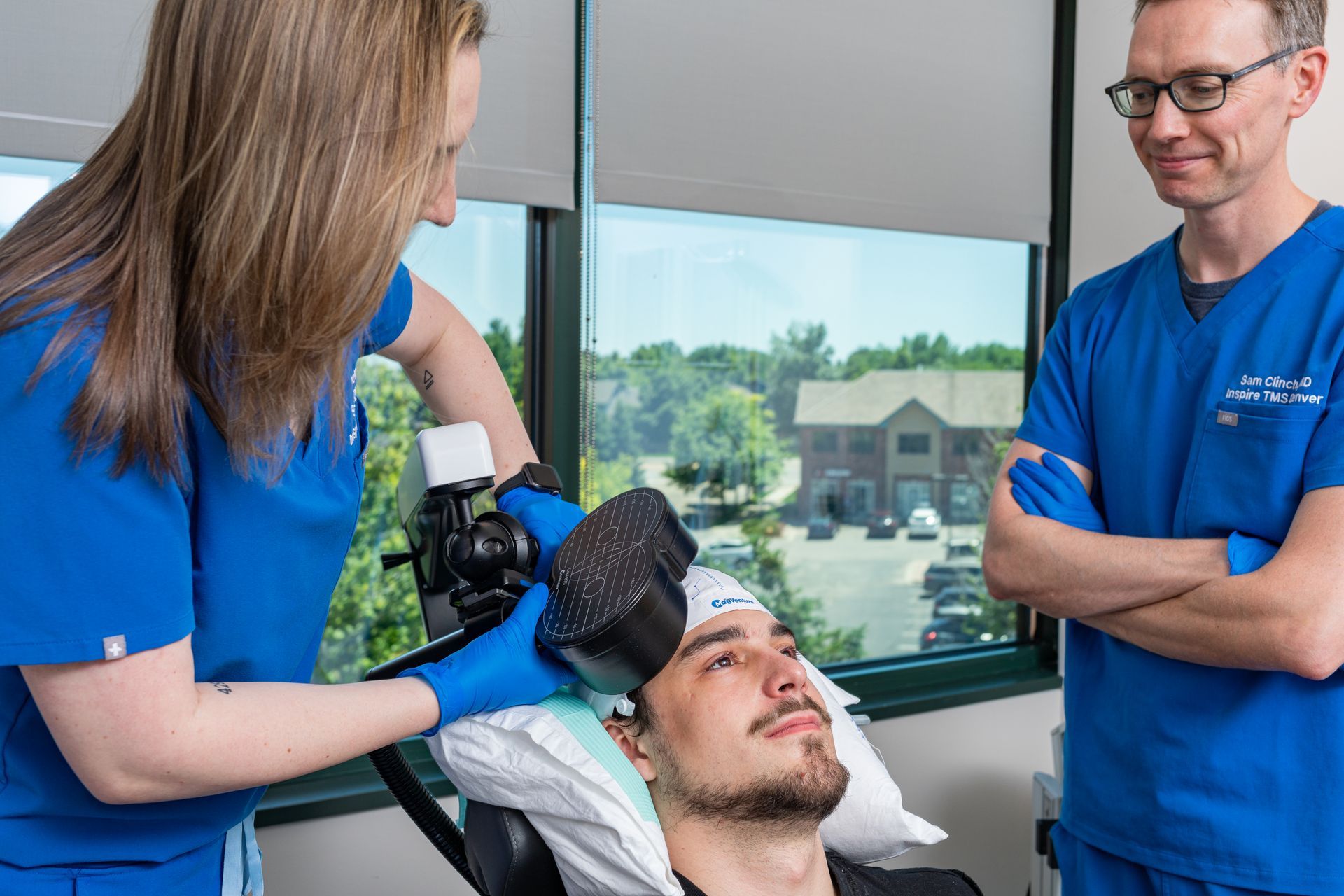 A man is being examined by a nurse and a doctor in a hospital room.