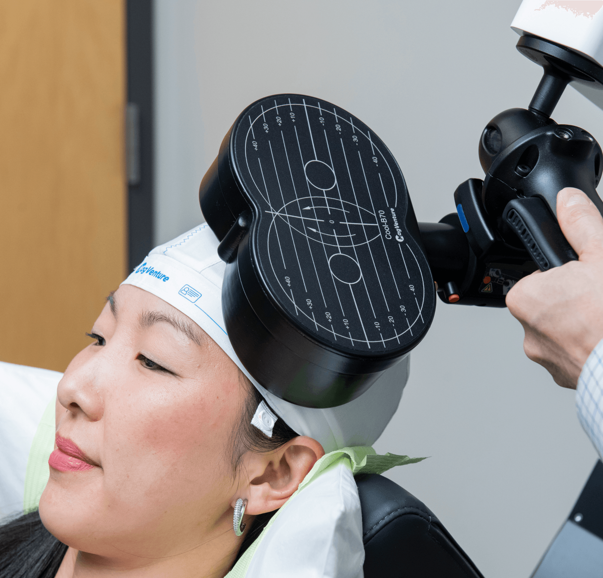 a woman is sitting in a chair with a device on her head