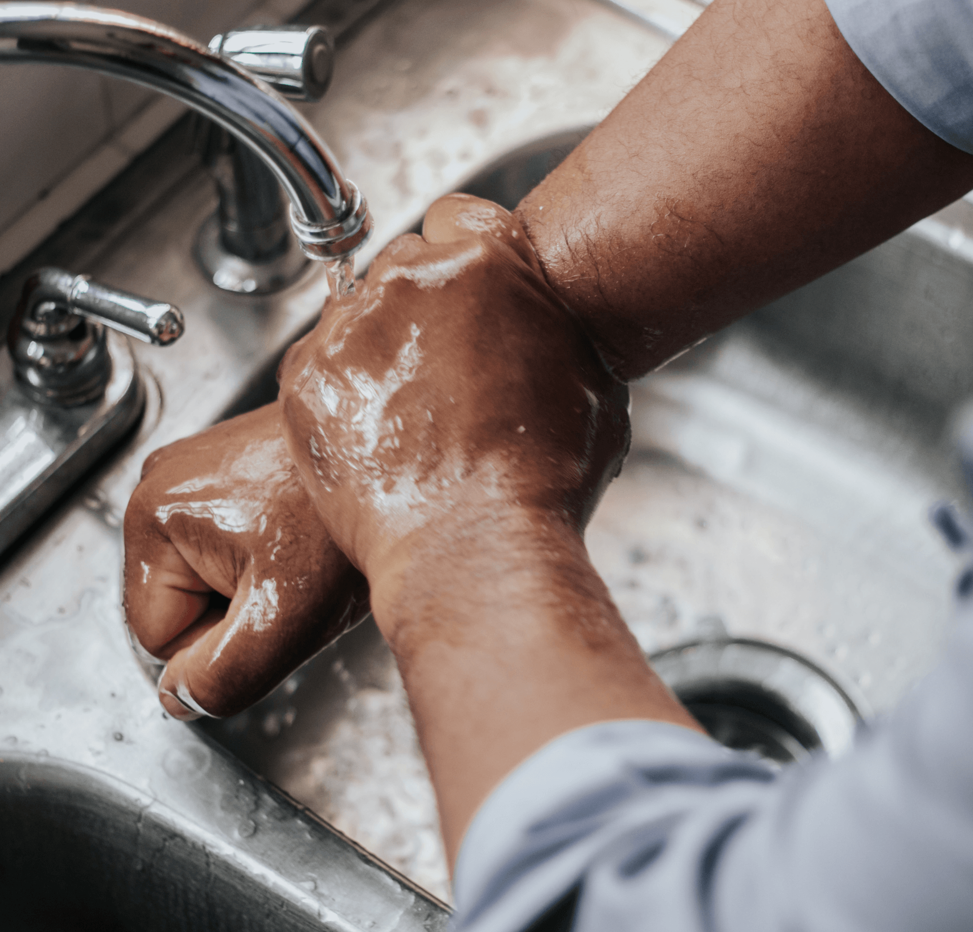 a person is washing their hands in a kitchen sink