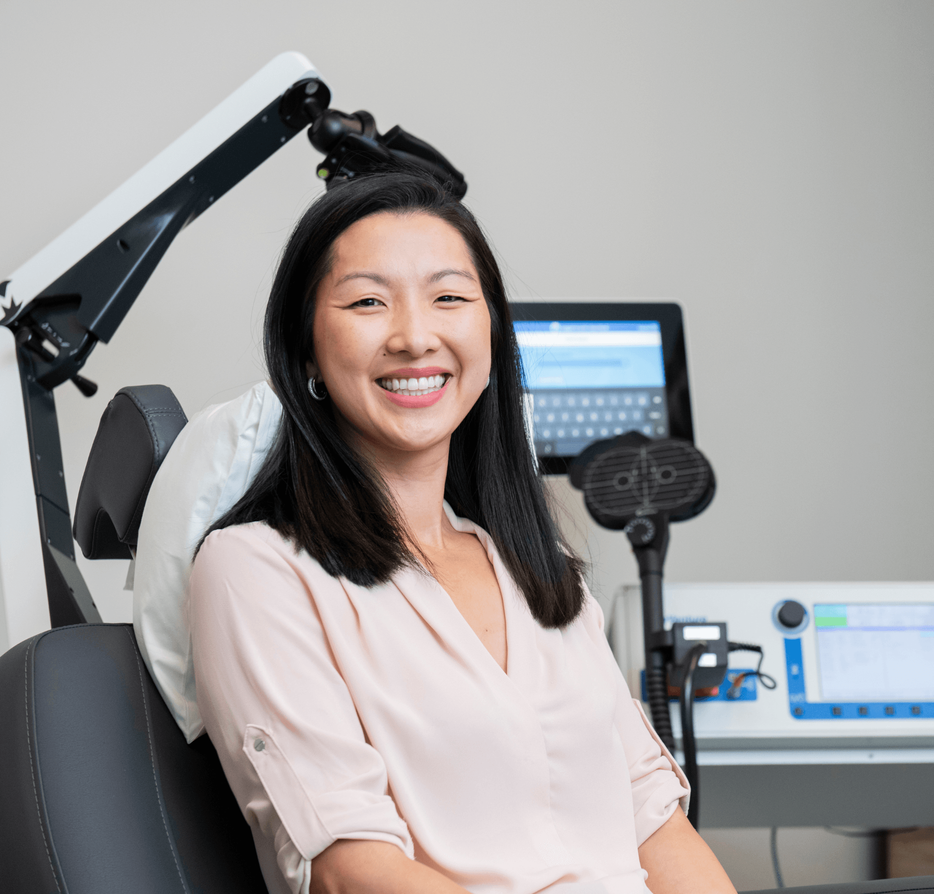 a woman is smiling while sitting in a chair in front of a machine .