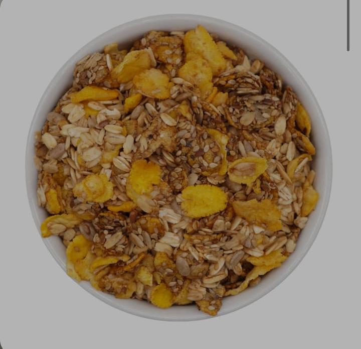 Tazón de cereal: granola, copos, semillas, en un tazón blanco.