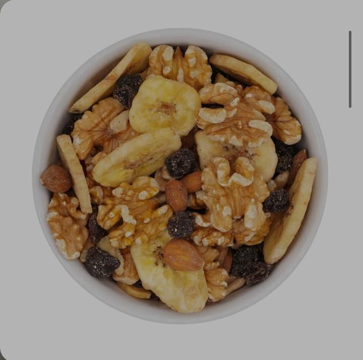Tazón de mezcla de frutos secos con plátanos, nueces, almendras y pasas.