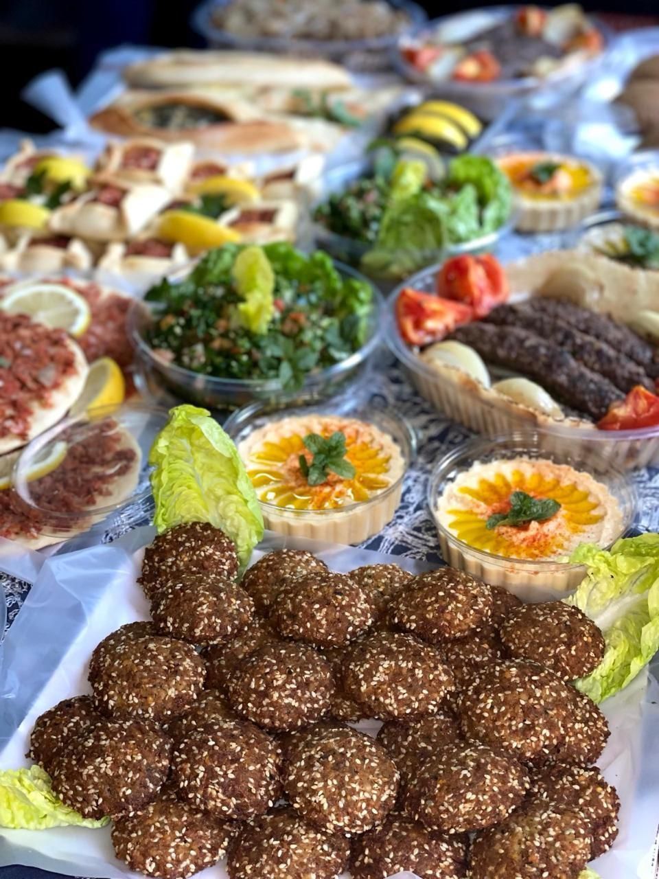 Bandeja de aperitivos y postres variados, que incluye champiñones rellenos, hierbas y platos horneados.