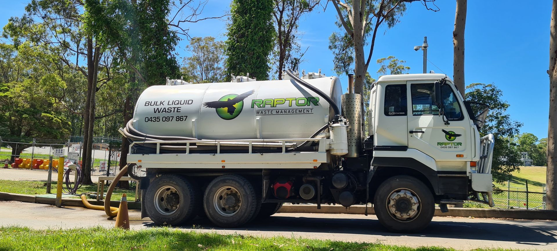 White septic truck parked on grass next to trees — Raptor Waste Management in Coolangatta, QLD