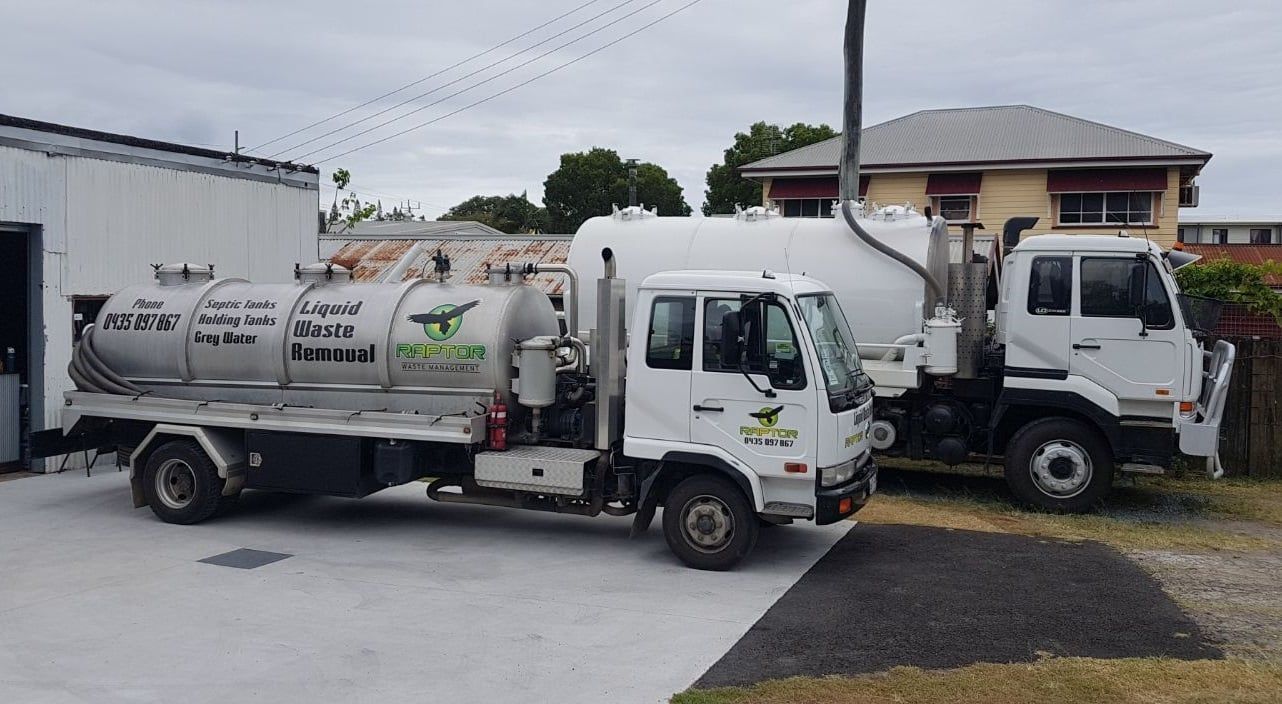Two White Septic Trucks Parked Outside a Building — Raptor Waste Management in Coolangatta, QLD
