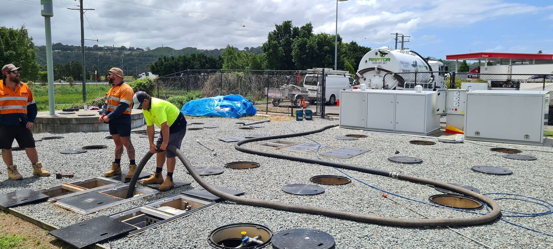 Three Workers in Safety Vests Vacuuming a Gravel Lot — Raptor Waste Management in Coolangatta, QLD