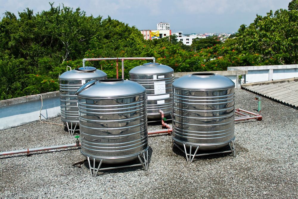 Four Stainless Steel Water Tanks on a Rooftop — Raptor Waste Management in Coolangatta, QLD