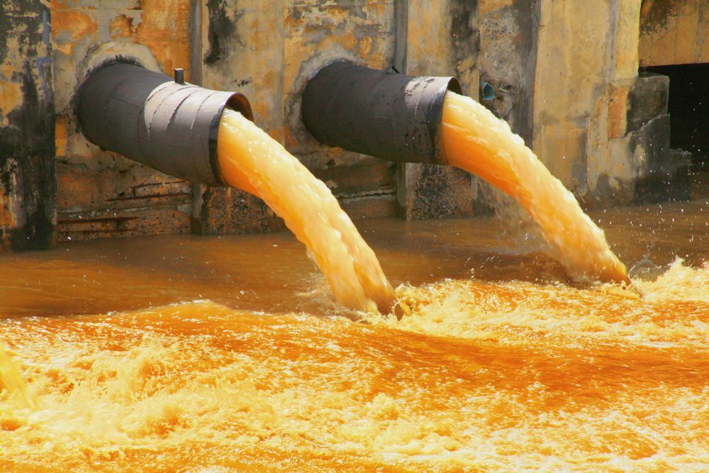 Tubes Pouring Orange Liquid Into Murky Water — Raptor Waste Management In Ormeau, QLD