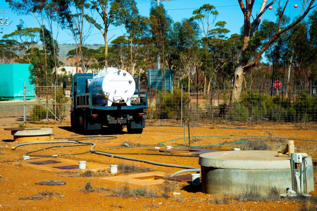 Tanker Truck Near Water Storage Tanks and Trees — Raptor Waste Management In Terranora, NSW