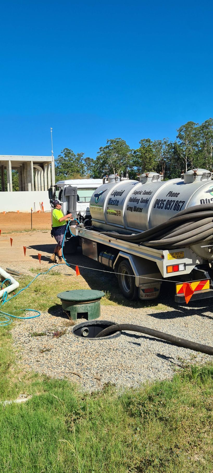 A septic tank pumping truck servicing a residential property under a clear blue sky — Raptor Waste Management in Coolangatta, QLD