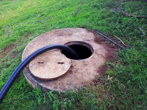 A Concrete Manhole With a Partially Open Lid — Raptor Waste Management in Coolangatta, QLD