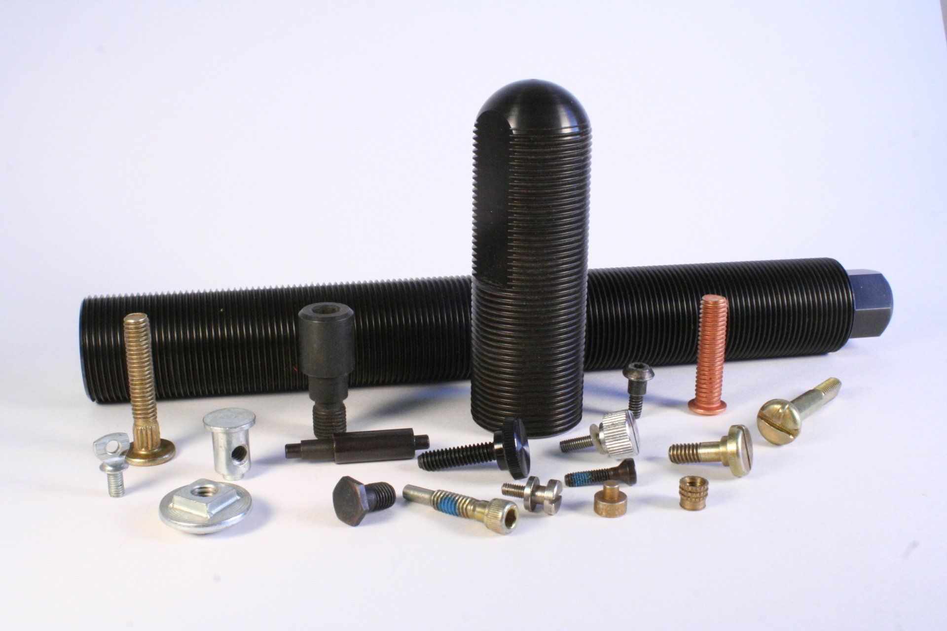 A bunch of different types of nuts and bolts on a white surface