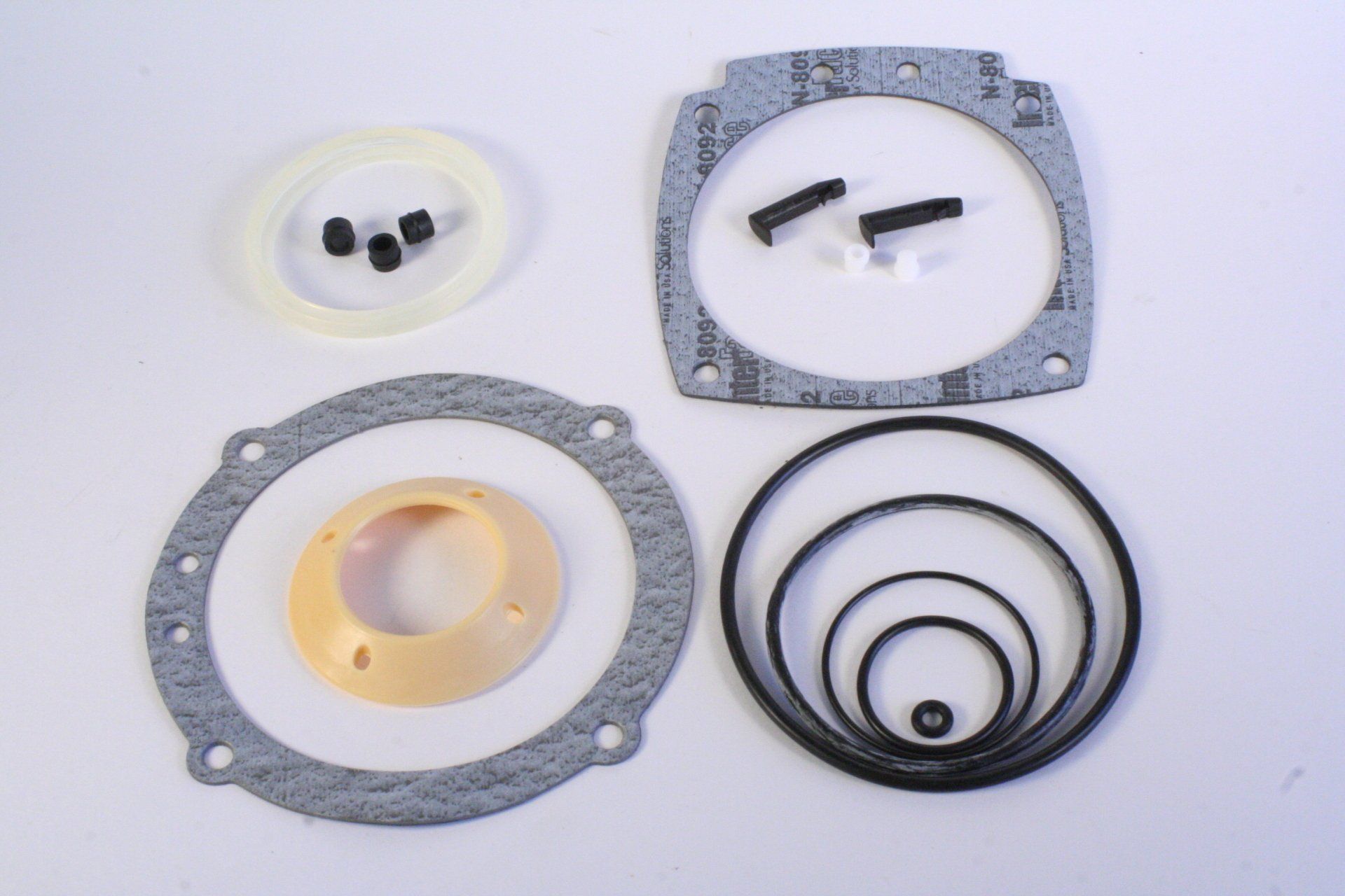 A set of gaskets and washers on a white surface
