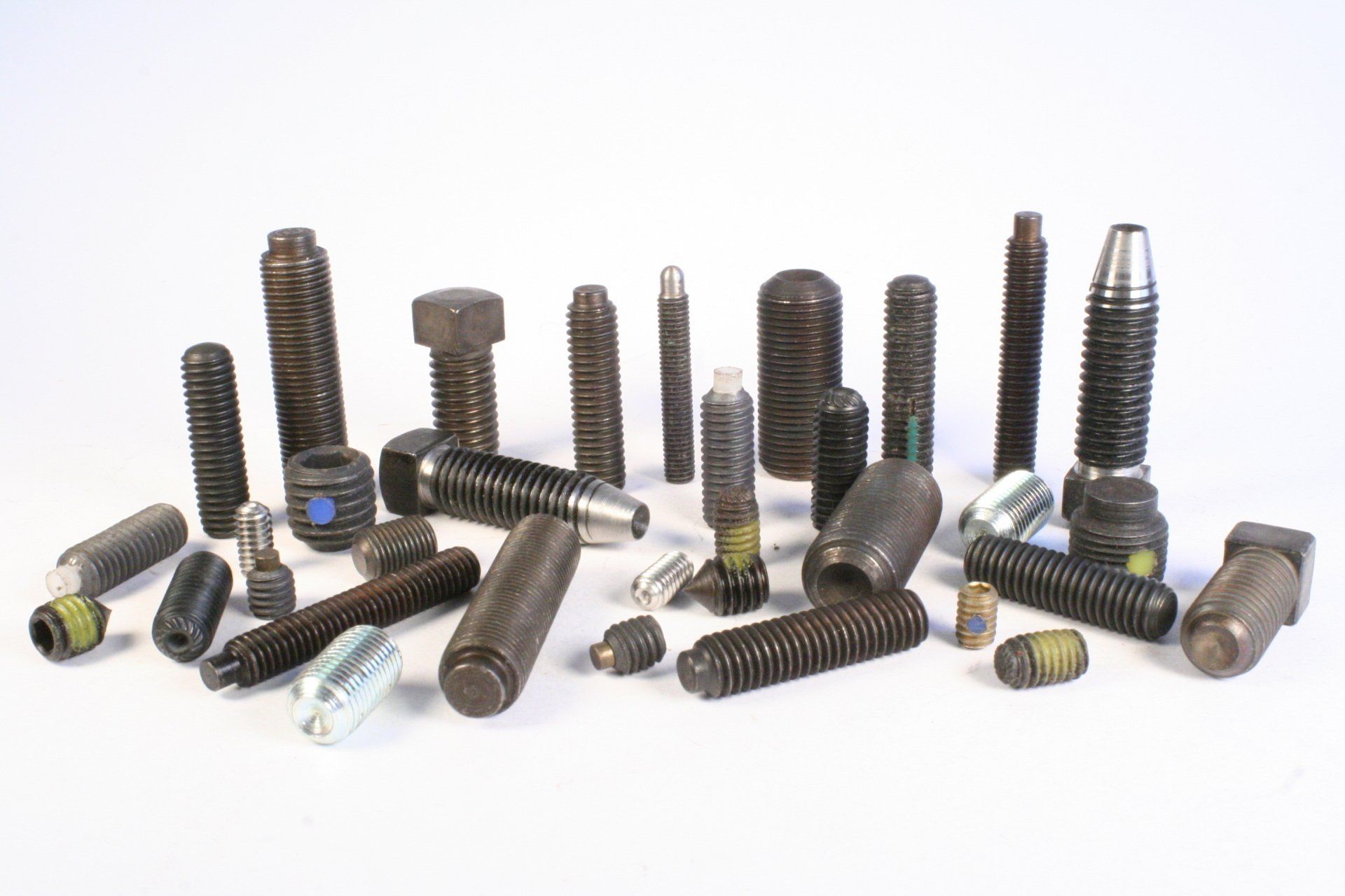 There are many different types of screws and nuts on the table.