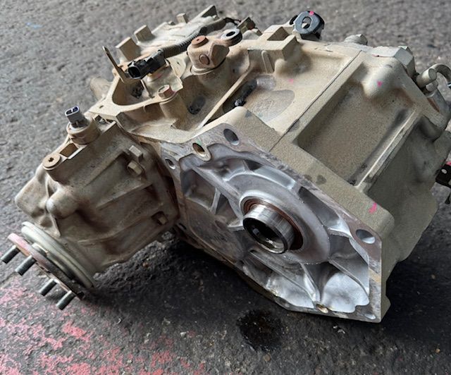 Open transfer case lying on a concrete surface; appears to be from a vehicle.
