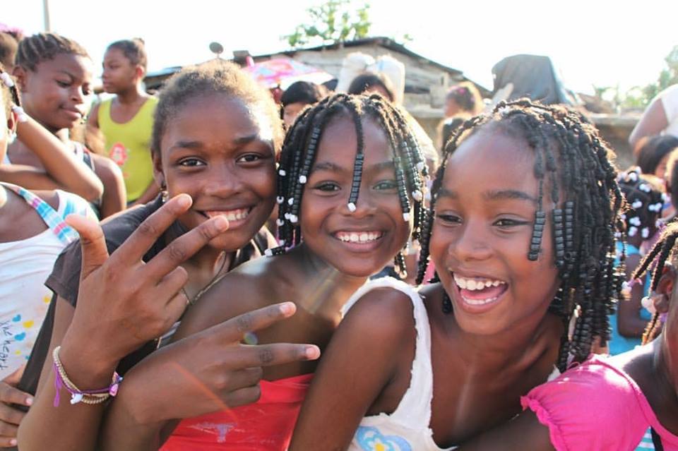 A group of young girls are posing for a picture and smiling