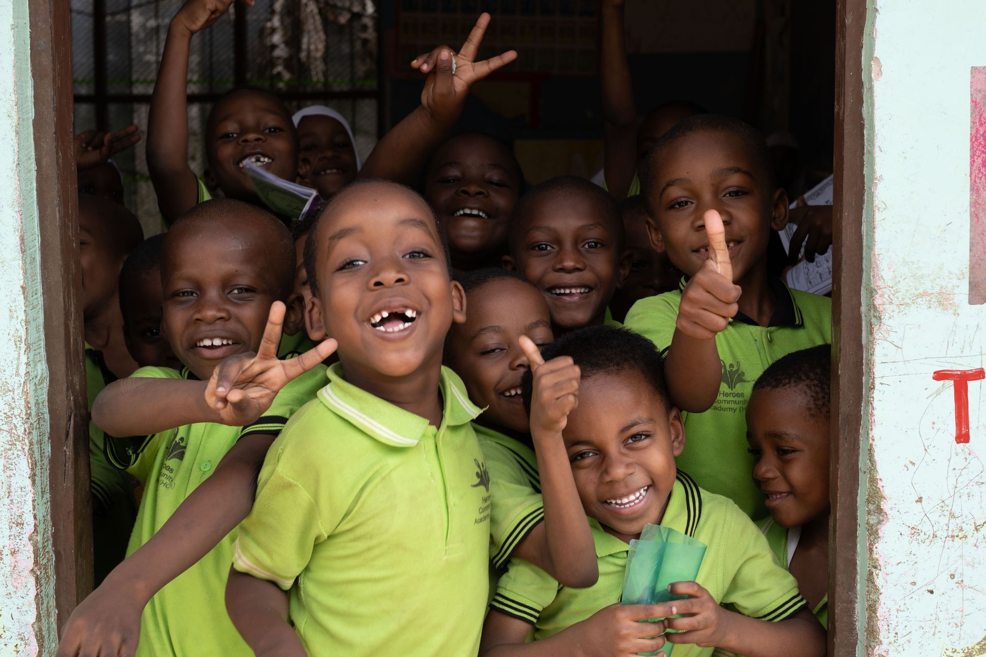 A group of children wearing masks are posing for a picture.