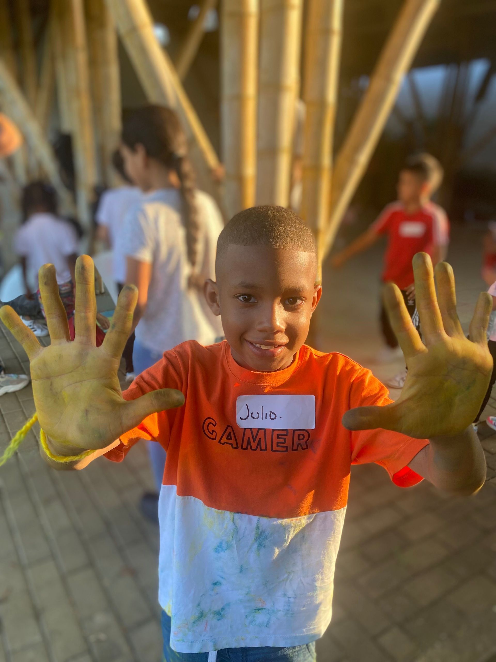 A young boy is holding up his dirty hands.