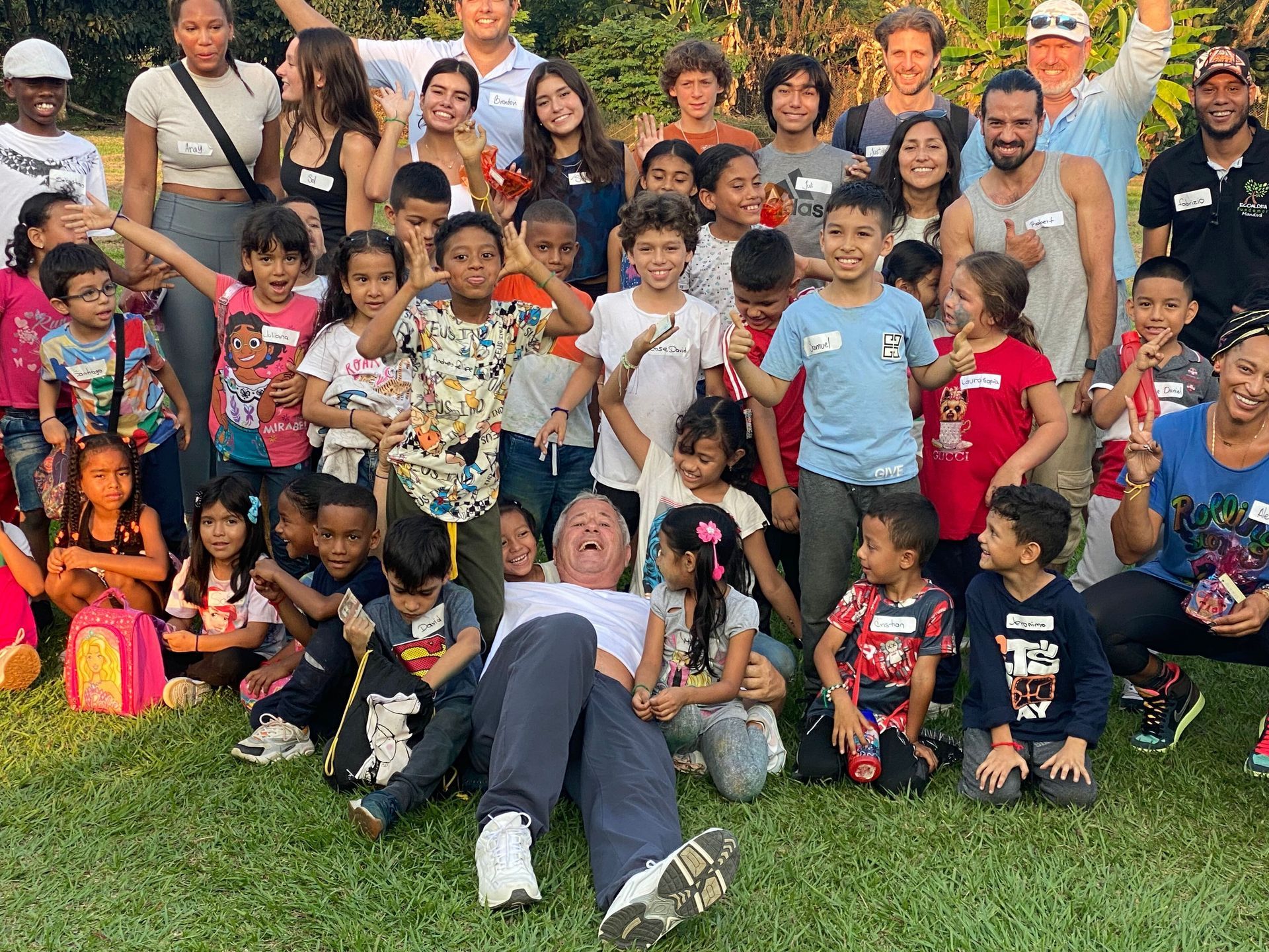 A large group of people are posing for a picture in a park.