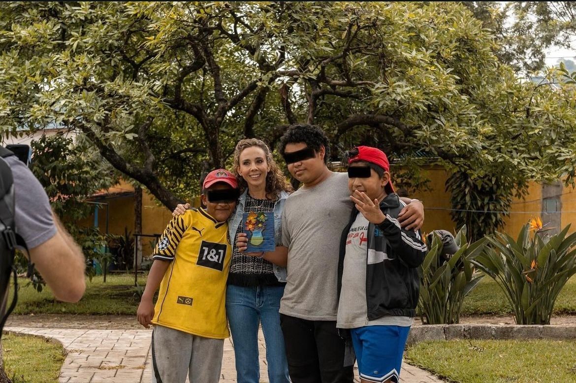 A man is taking a picture of a group of people posing for a picture.