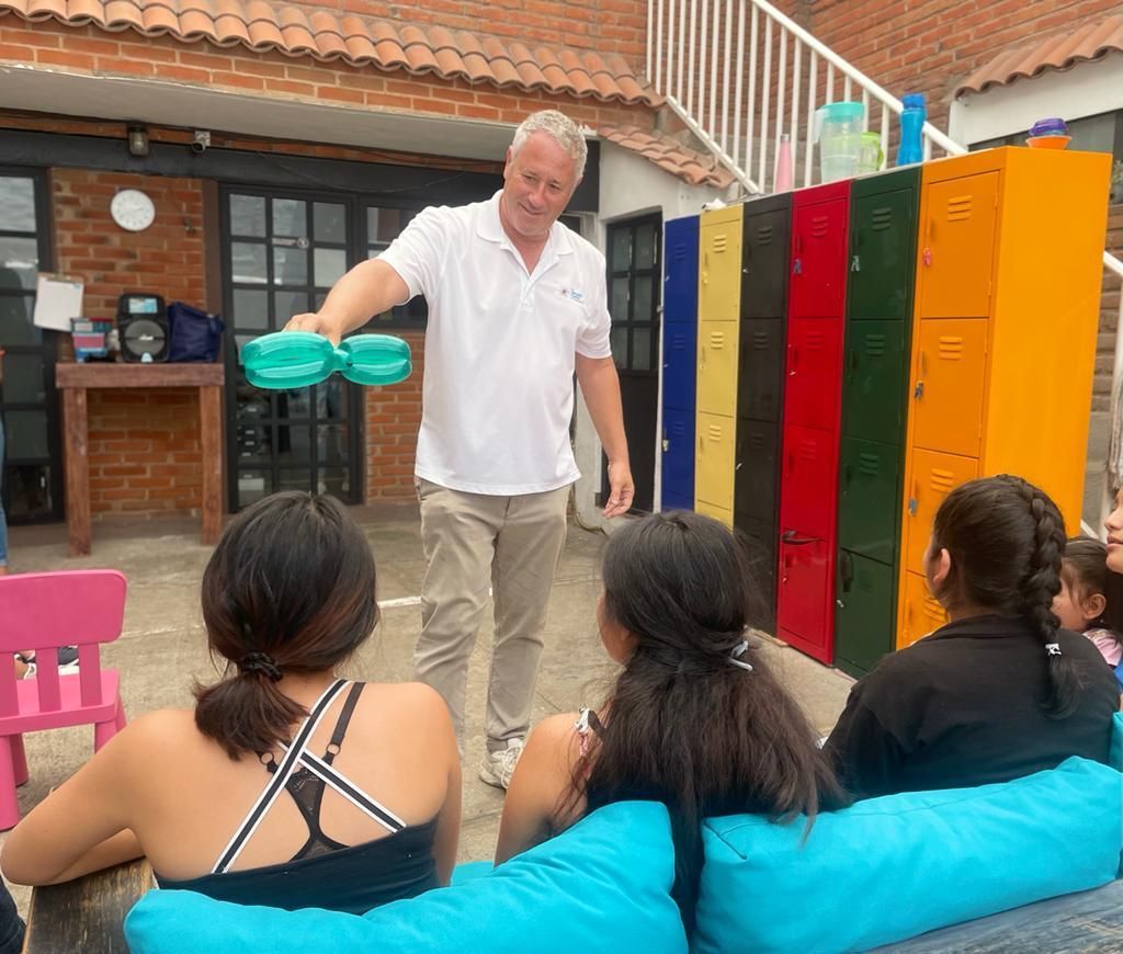 A man is doing magic tricks for a group of people sitting on a couch.