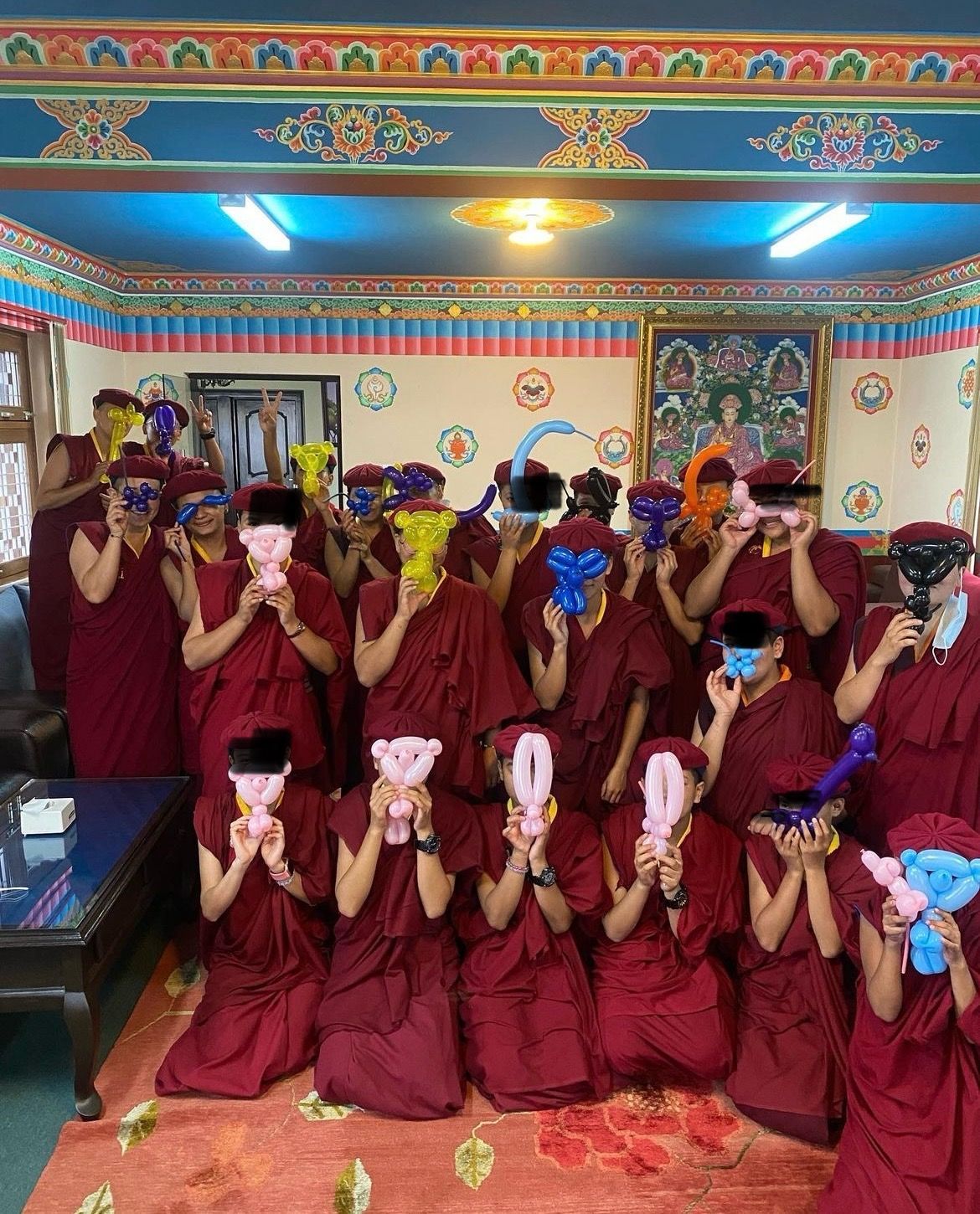 A group of people wearing masks and holding balloons in a room