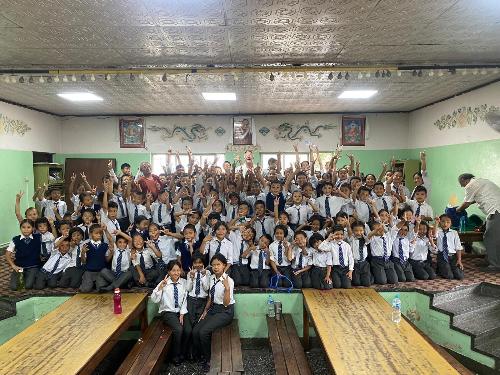 A large group of Nepalese children are posing for a picture in a classroom  Andy Stein of orphaned starfish foundation