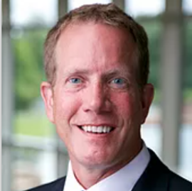 A man in a suit and tie is smiling for the camera.