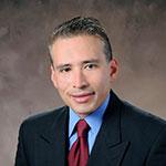 A man in a suit and tie is smiling for the camera.