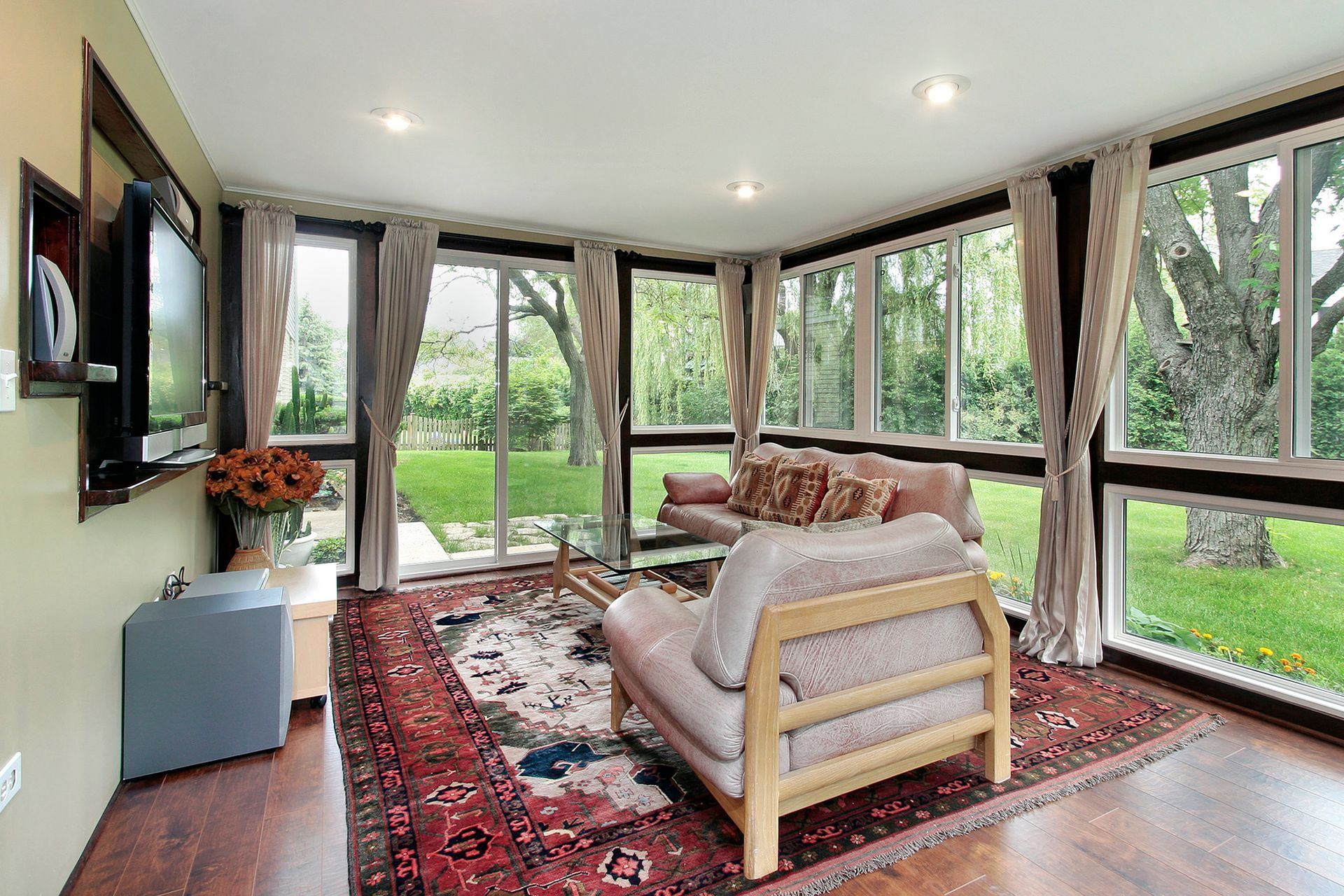 a living room with a lot of windows and a rug