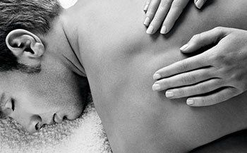 A man is getting a massage from a woman in a black and white photo.
