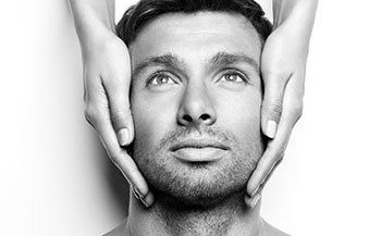 A man is getting a massage on his face by a woman.