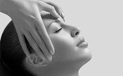 A woman is getting a head massage in a black and white photo.