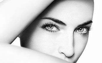 A close up of a woman 's face with her hand on her face.