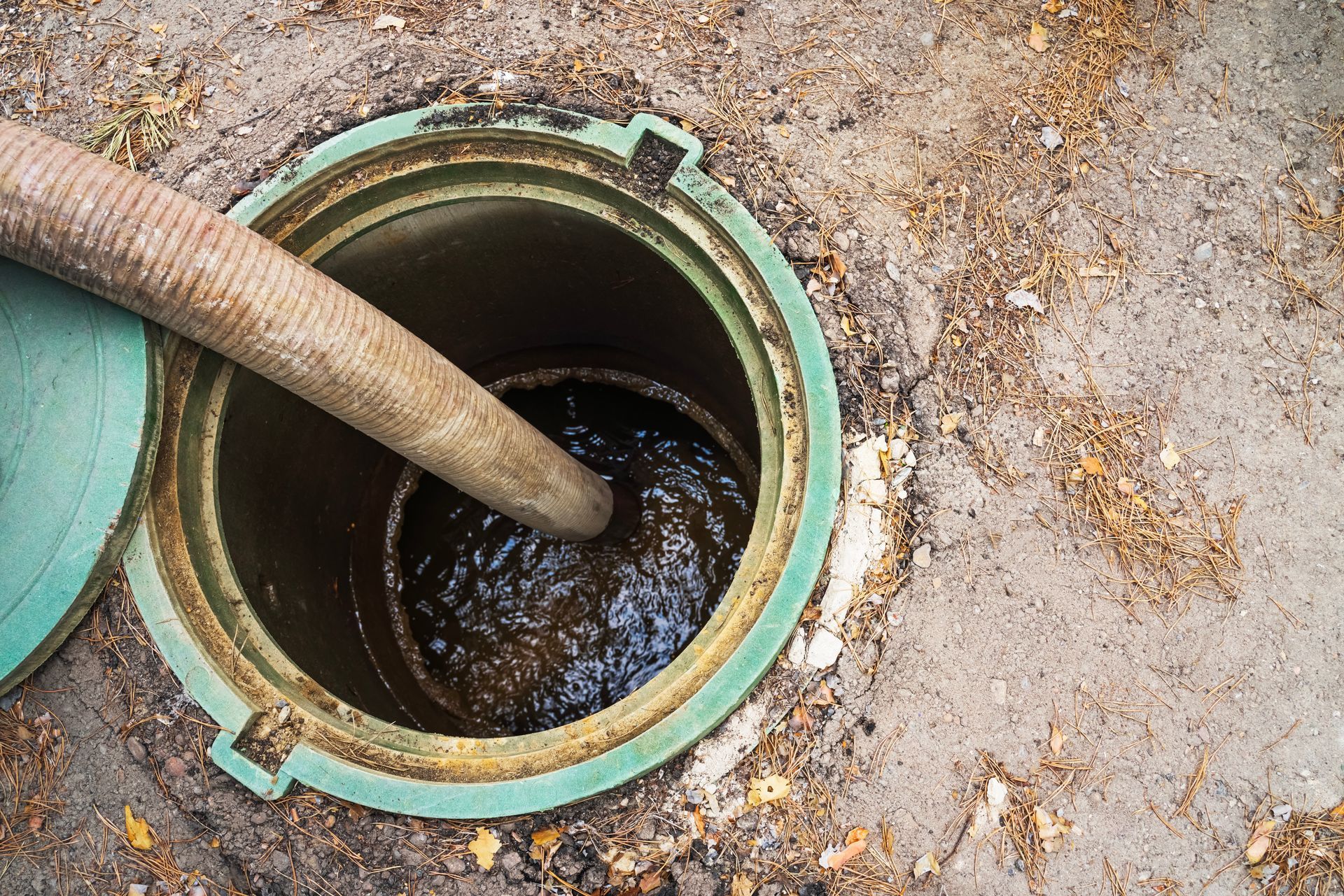 A clogged septic tank, with a draining pipe inside it. A clogged septic tank, with a draining pipe inside it.