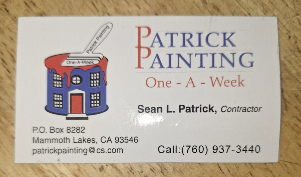 A small dog is taking a bath in a wooden bucket.