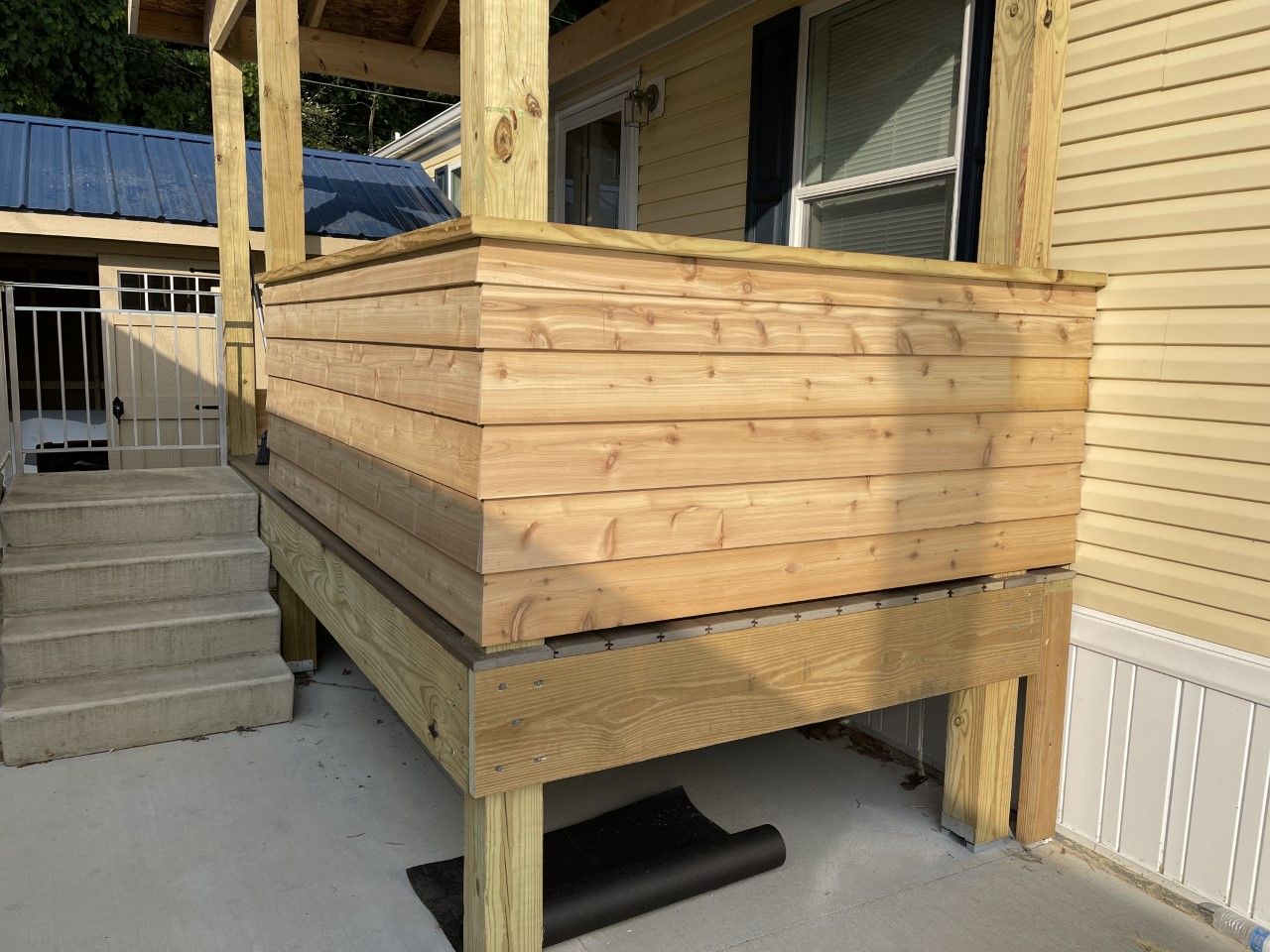 A wooden porch is being built on the side of a house.