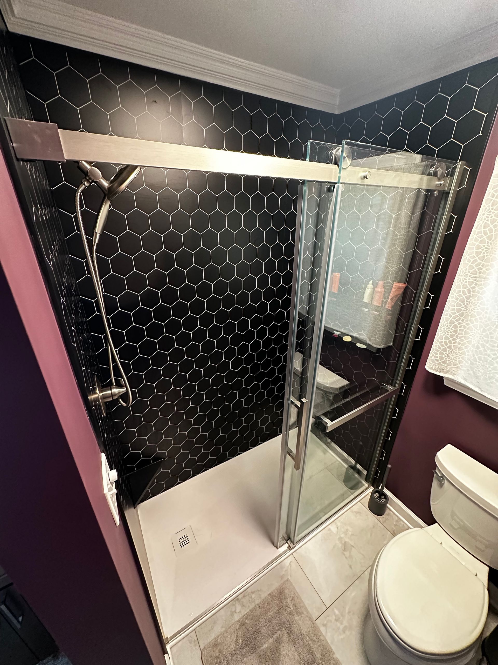 A bathroom with a shower , toilet and mirror