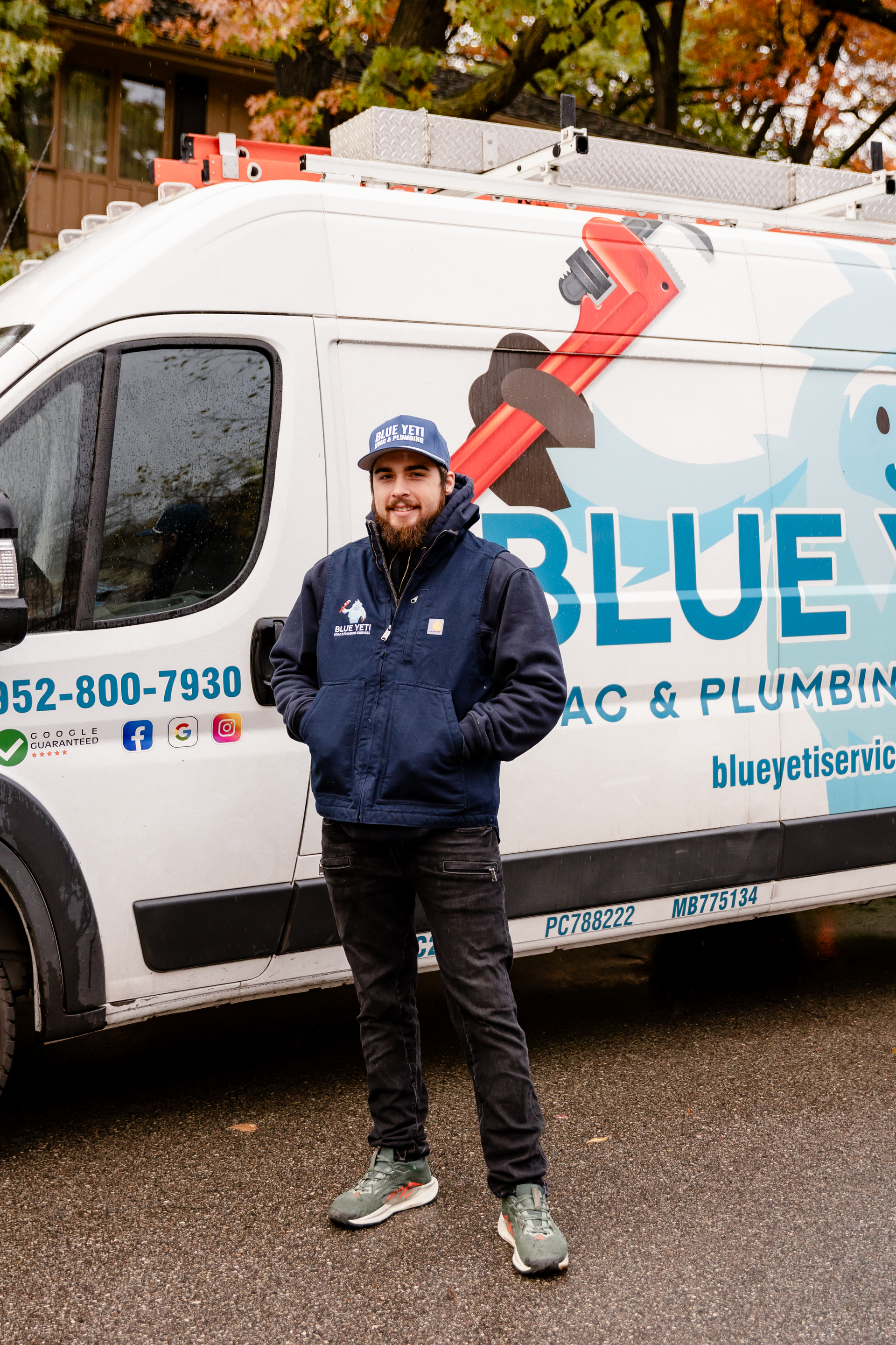 Technician standing next to Blue Yeti HVAC Plumbing HVAC van